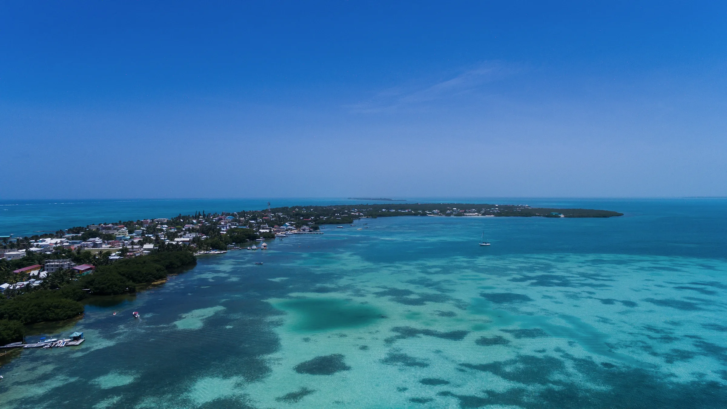 Aerial view of Caye Caulker and its shallow turquoise waters.
