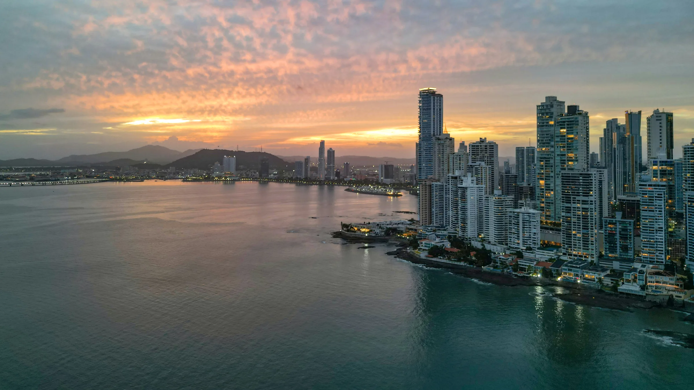 High-rise buildings beside Panama City’s bay at sunset.