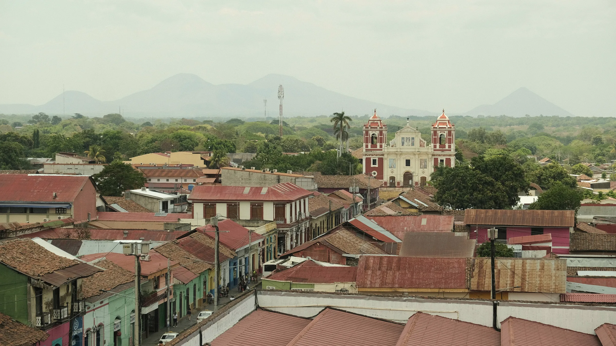 Rooftops and churches in León with a volcanic range in the background.