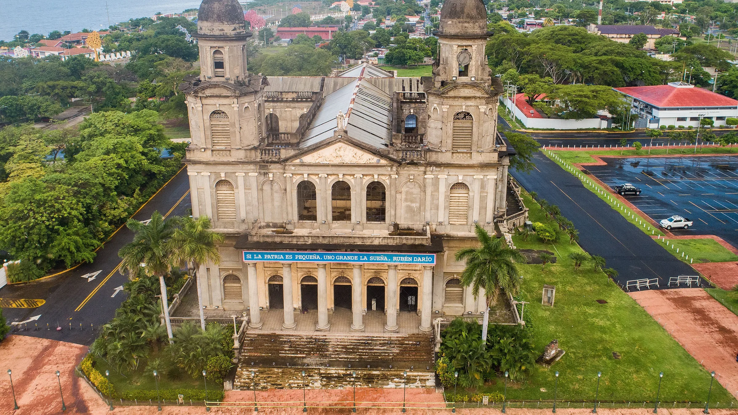 Aerial view of Managua’s old cathedral, with palms, gardens and the city behind.