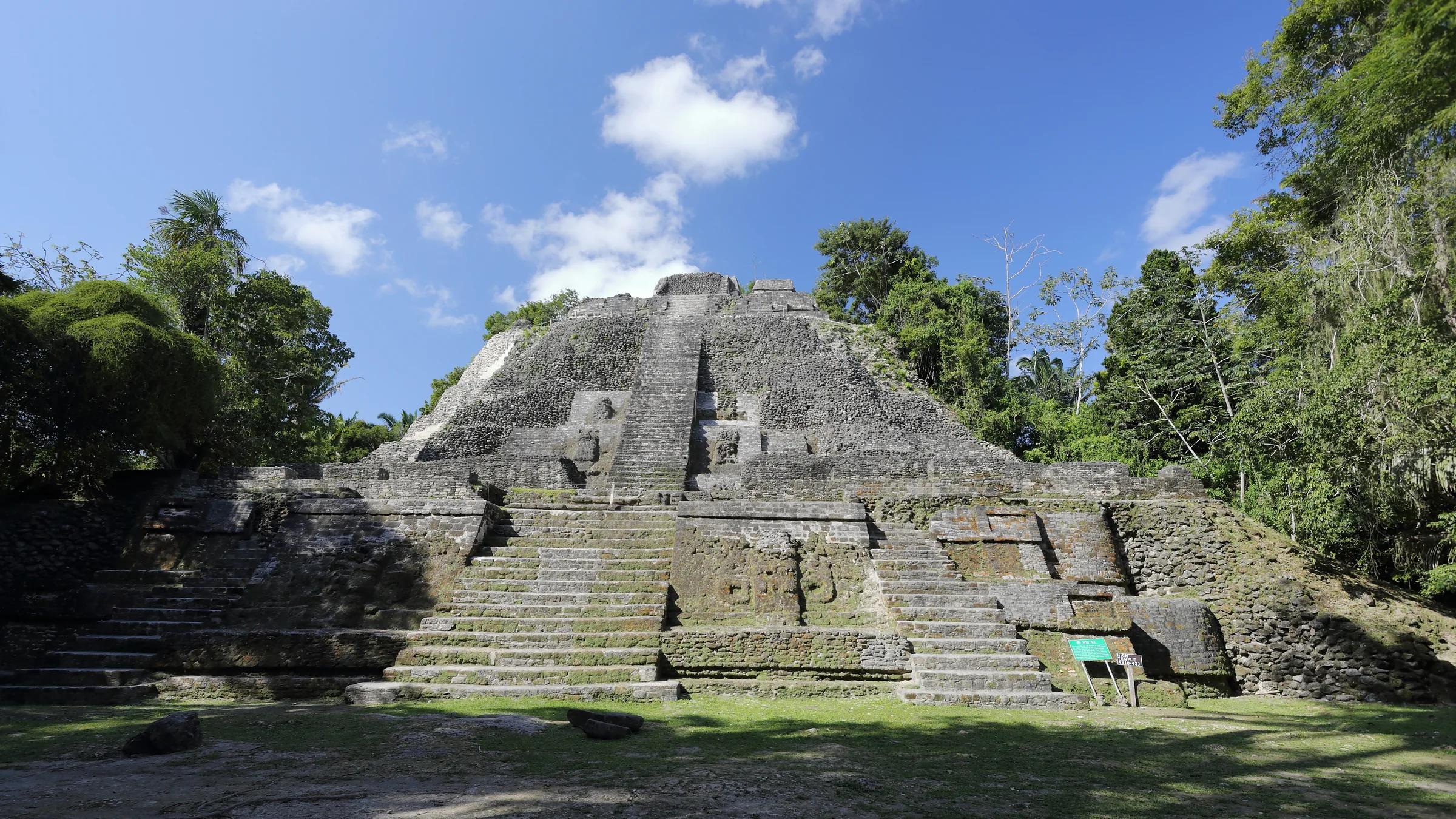 Stepped stone temple surrounded by trees at Lamanai.
