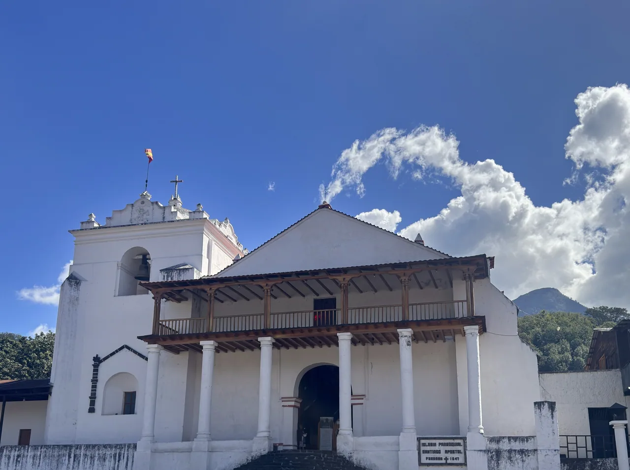 White facade, bell tower and wooden balcony of Santiago Apóstol church.