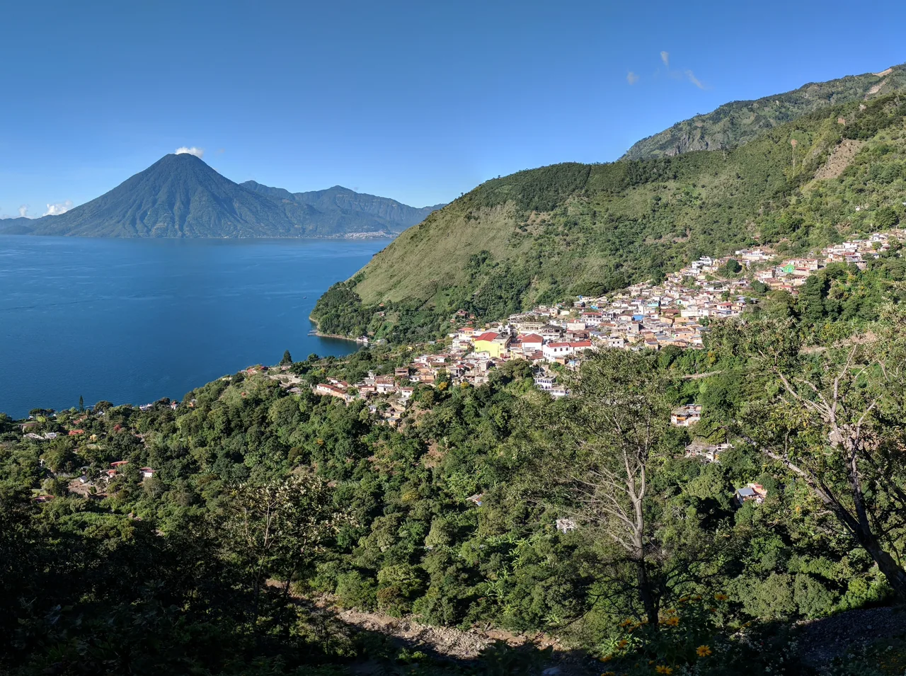 Santa Cruz La Laguna on a hillside above the lake, with mountains behind.