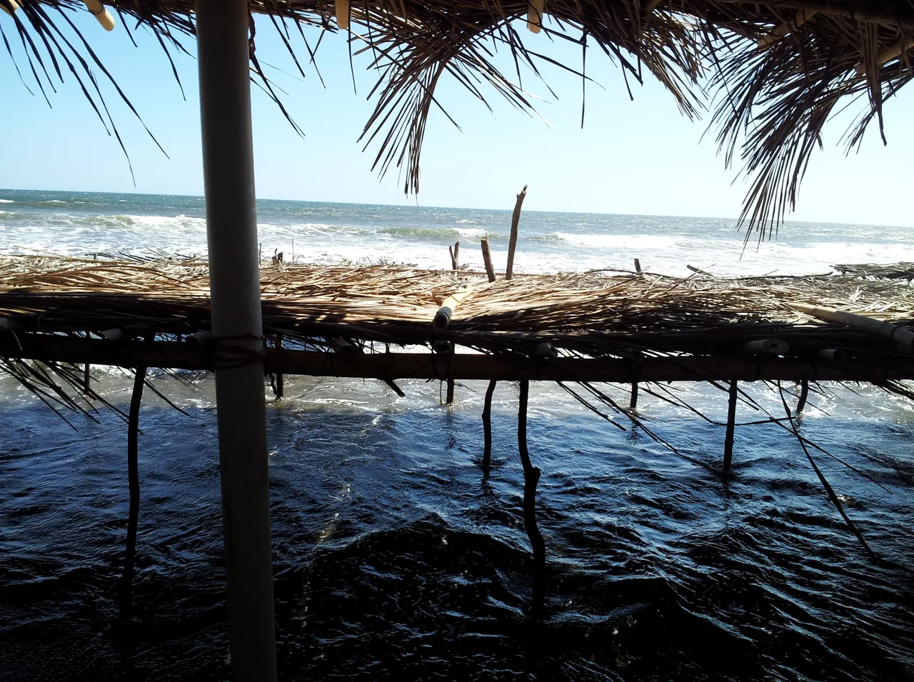 Oleaje de Playa El Espino visto bajo un techo de palma.