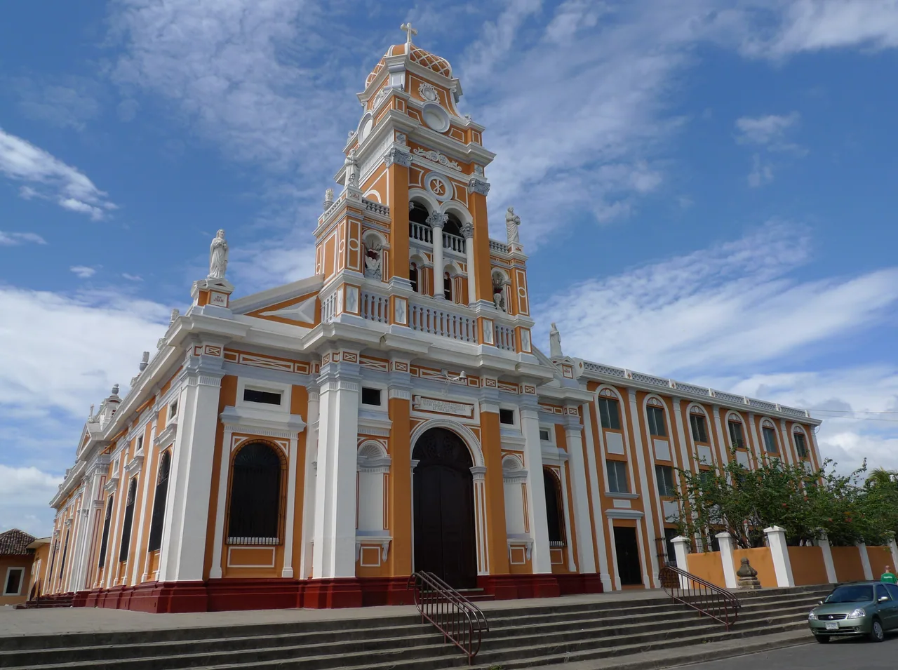 White and cream facade of Xalteva church with its central tower.