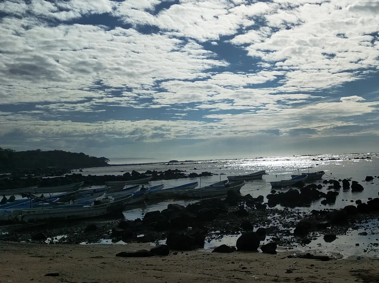 Lanchas y rocas en la costa de Los Cóbanos.
