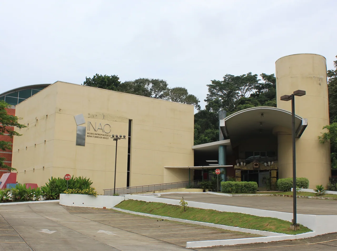 Edificio color arena rotulado como Museo Antropológico Reina Torres de Araúz, con entrada cubierta y aparcamiento vacío.