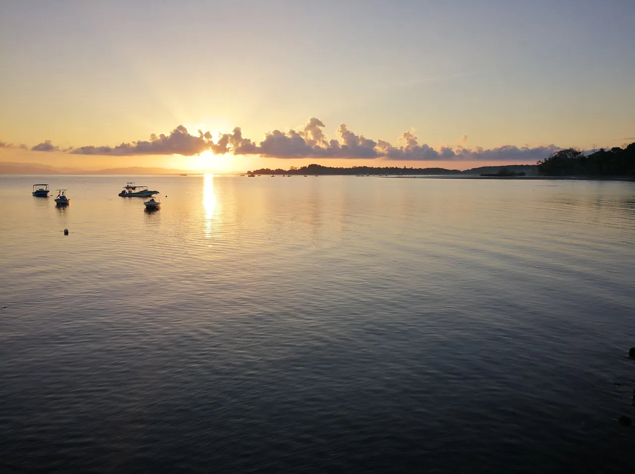 Sunrise and boats seen from the Puerto Jiménez pier.