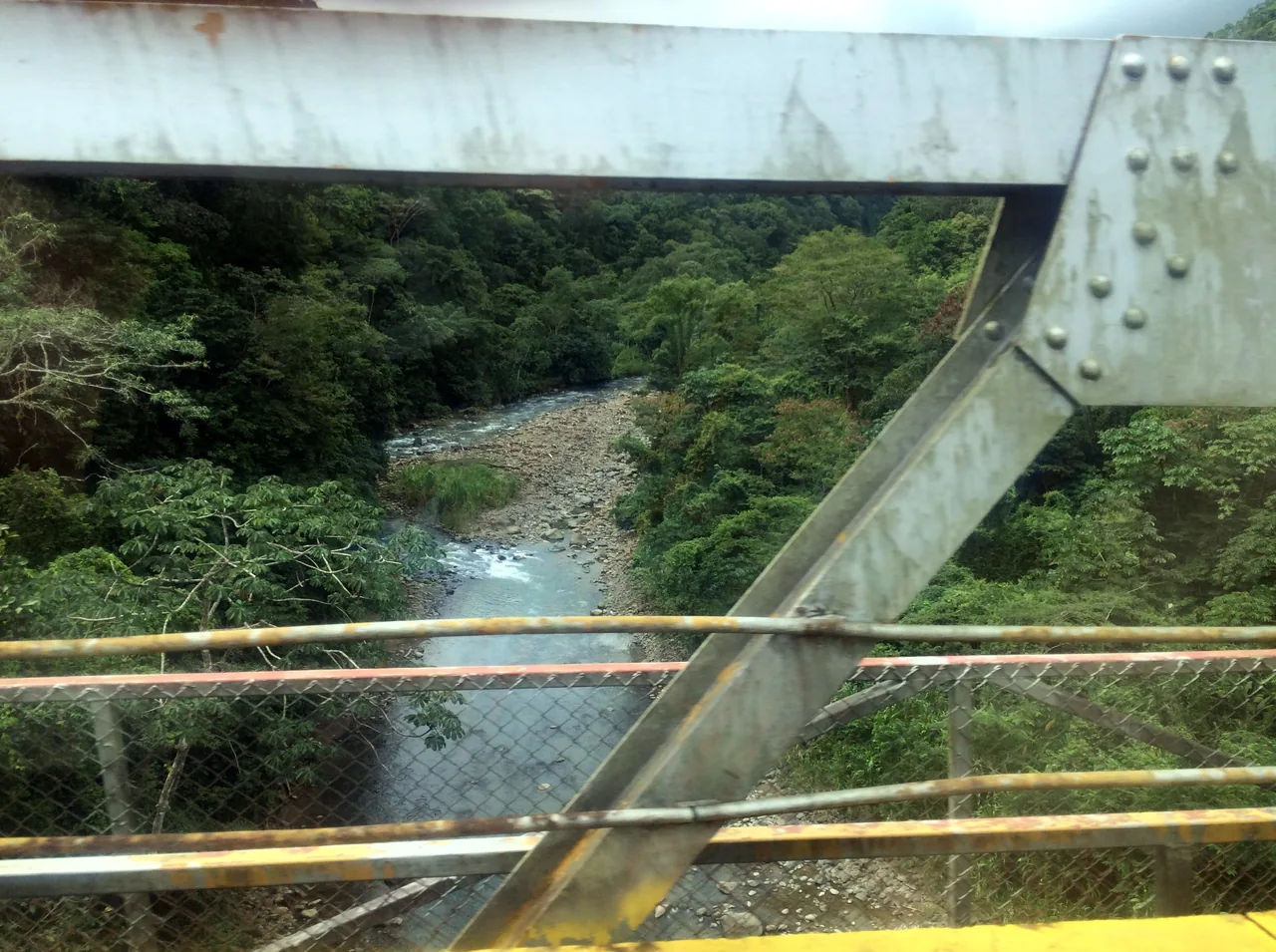 Peñas Blancas River and forest seen from a metal bridge.